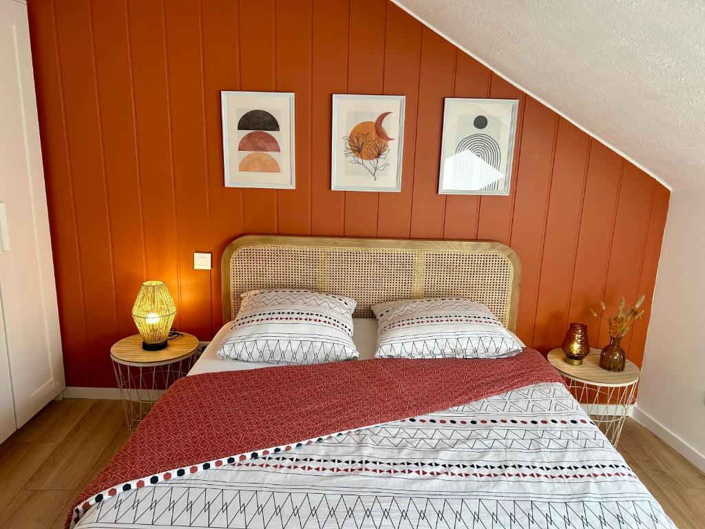 um quarto com uma cama com paredes e quadros cor-de-laranja em Douce Agathe - Duo-Groupe, Chaleureux, Tram 200m, Centre 10min em Estrasburgo
