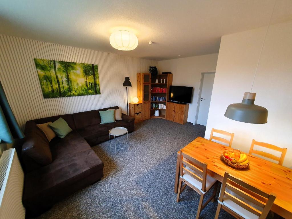 a living room with a couch and a table at radfreundliches Wohlfühl-Apartment mit Terrasse und Parkplatz - FeWo Woody in Schwerin