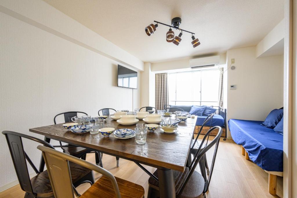 a dining room with a wooden table and chairs at PREMIER suite Shinjuku takadanobaba in Tokyo