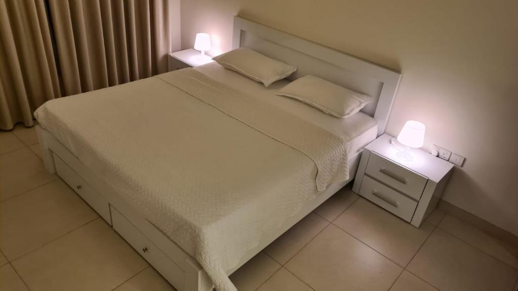- une chambre avec un lit et 2 lampes dans l'établissement Badr alqurm, à Wuţayyah