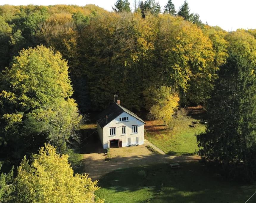 uma pequena casa branca no meio das árvores em Lac des Settons - Gîte 3* La Grignette em Moux-en-Morvan
