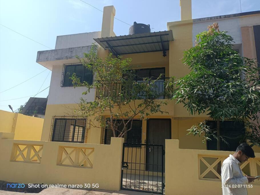 a man walking in front of a yellow building at 4 Bhk Independent Villa At Pushpanjali Residency Phase 2 Bunglow No A1 Owale Ghodberder Road Thane West in Thane