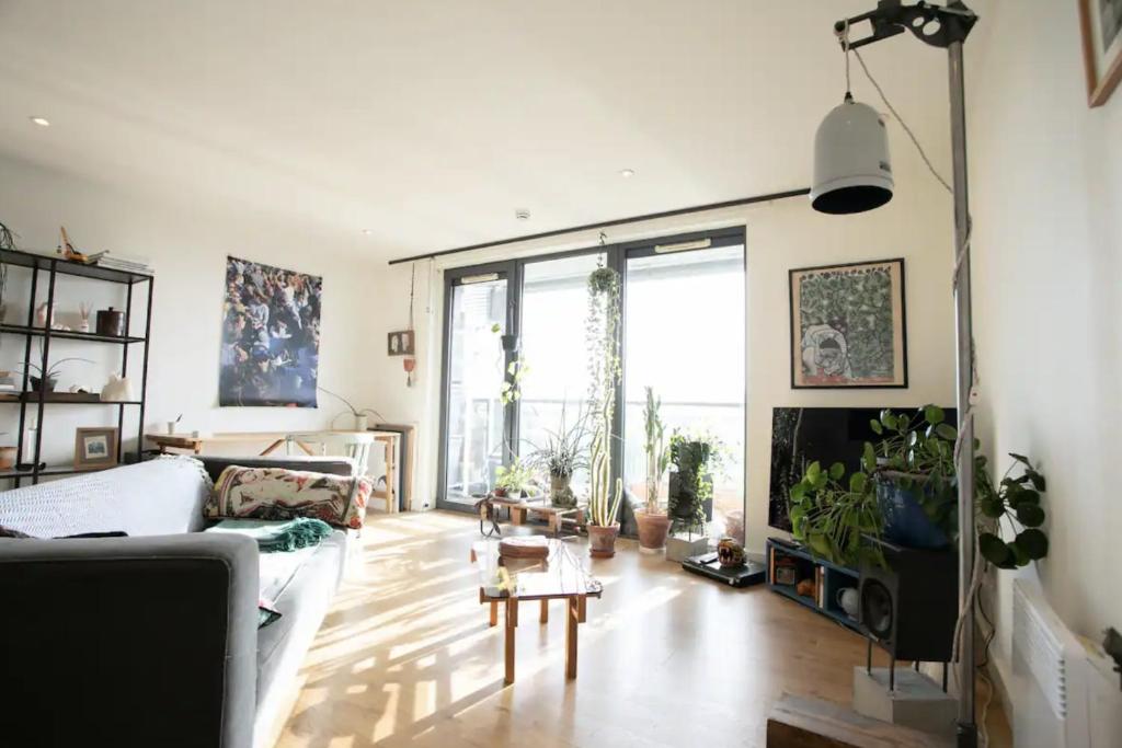 a living room with a couch and a tv at Bedroom & dedicated workspace in spacious flat in London