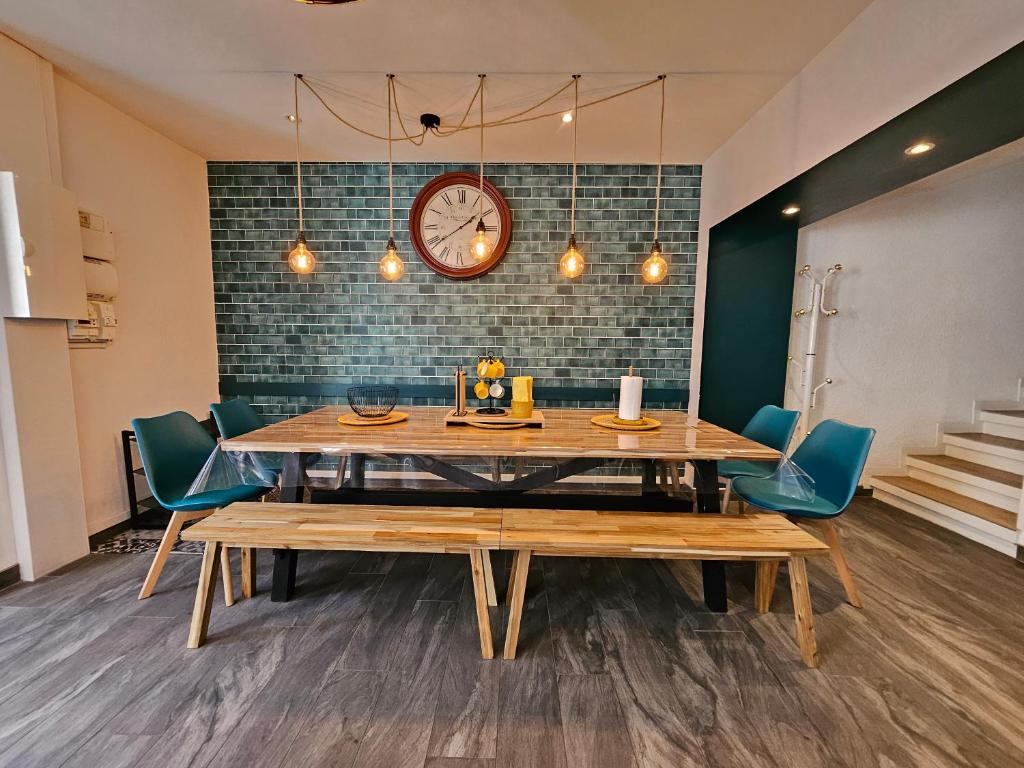 comedor con mesa, sillas y reloj en le loft bleu (12 couchages), en Sablons