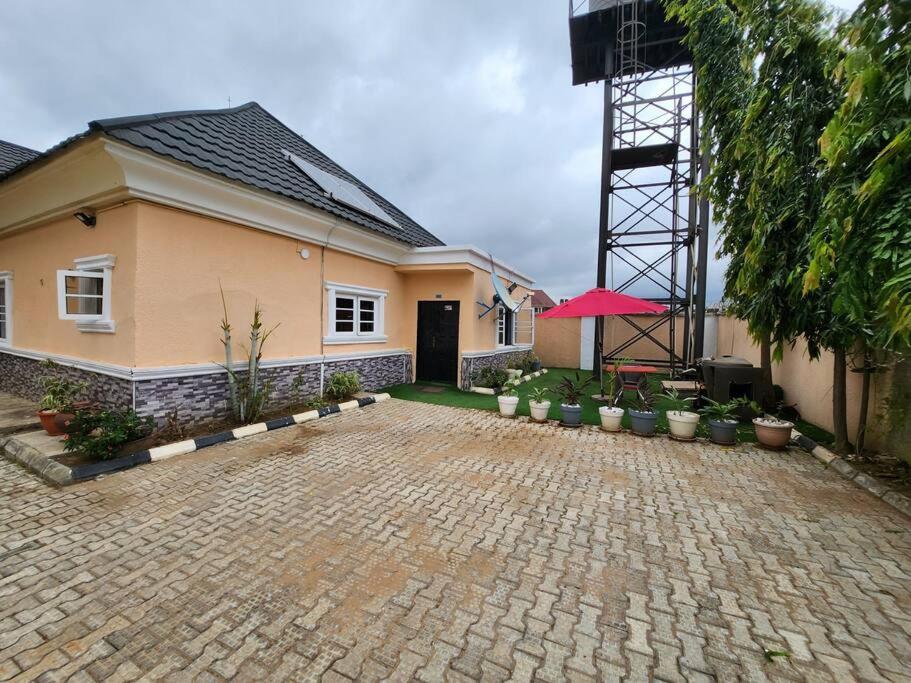 a house with a brick driveway in front of it at Asfranz Apartment Luxury One-Bedroom with Private Garden in Abuja