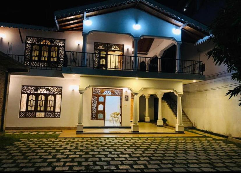 ein großes weißes Haus mit Balkon oben in der Unterkunft Leyon-Tourist Inn in Negombo