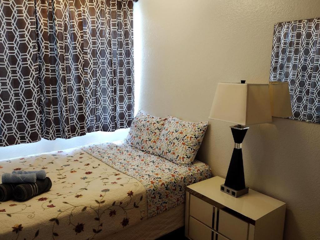 ein Schlafzimmer mit einem Bett mit einer Lampe und einem Fenster in der Unterkunft Room in a House in St Petersburg