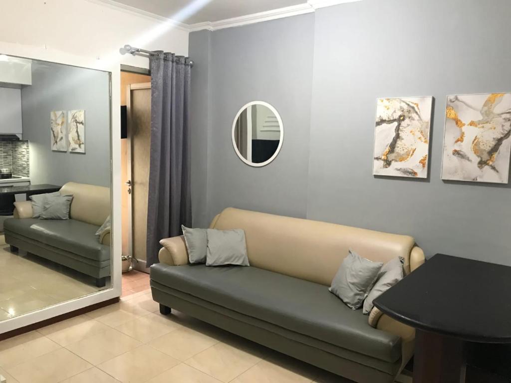un soggiorno con divano e specchio di Apartement Mediterania Palace Jakarta pusat a Giacarta