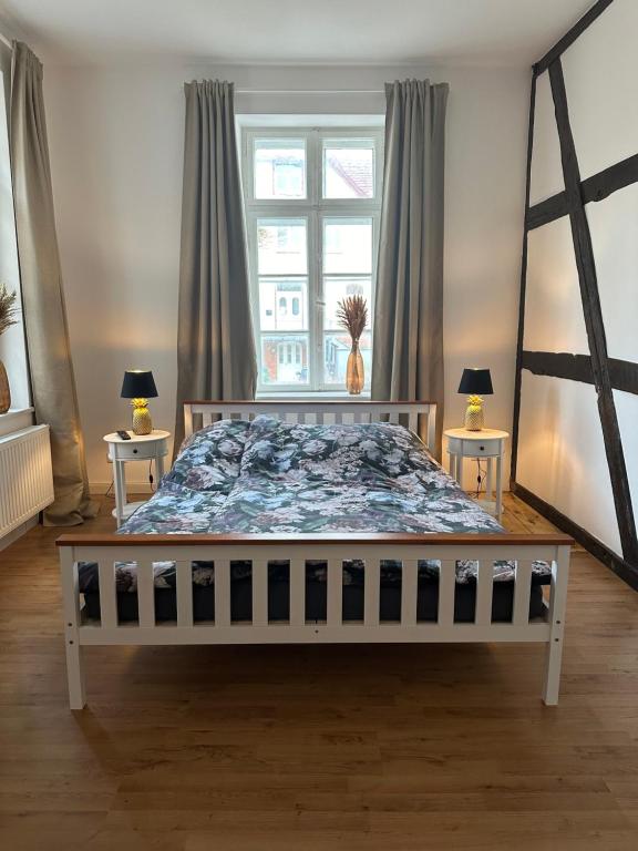 1 dormitorio con 1 cama grande y 2 mesas en Toscana, en Lübeck