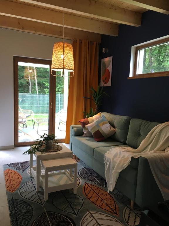 a living room with a green couch and a table at PIEPRZ i Wanilia - Kopalino dom z widokiem na las 3 pokoje taras parking WiFi - Pieprz in Kopalino