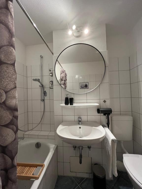 a bathroom with a sink and a tub and a mirror at Ferienwohnung AllgäuSchatz in Stadtnähe Kempten in Lauben