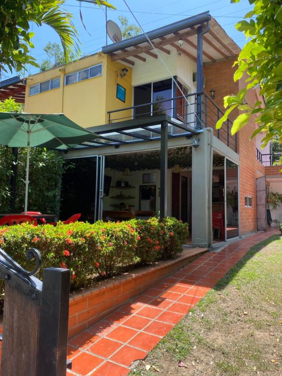 uma casa com uma varanda com um guarda-chuva em frente em Casa Vacacional Ciudadela Sol em San Jerónimo
