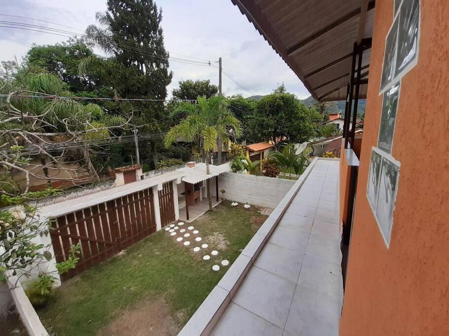 ein Balkon eines Hauses mit einem Garten in der Unterkunft Casa sobreposta alta em Boiçucanga - São Sebastião in São Sebastião