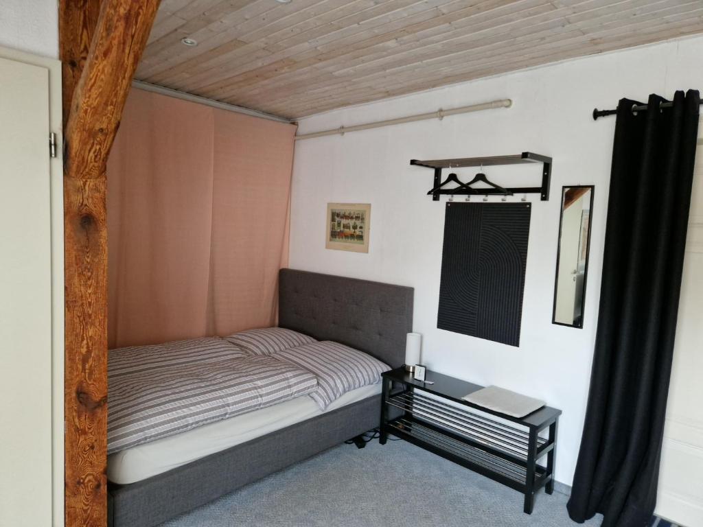 ワイマールにあるGästezimmer Johnの小さなベッドルーム(ベッド1台、テーブル付)