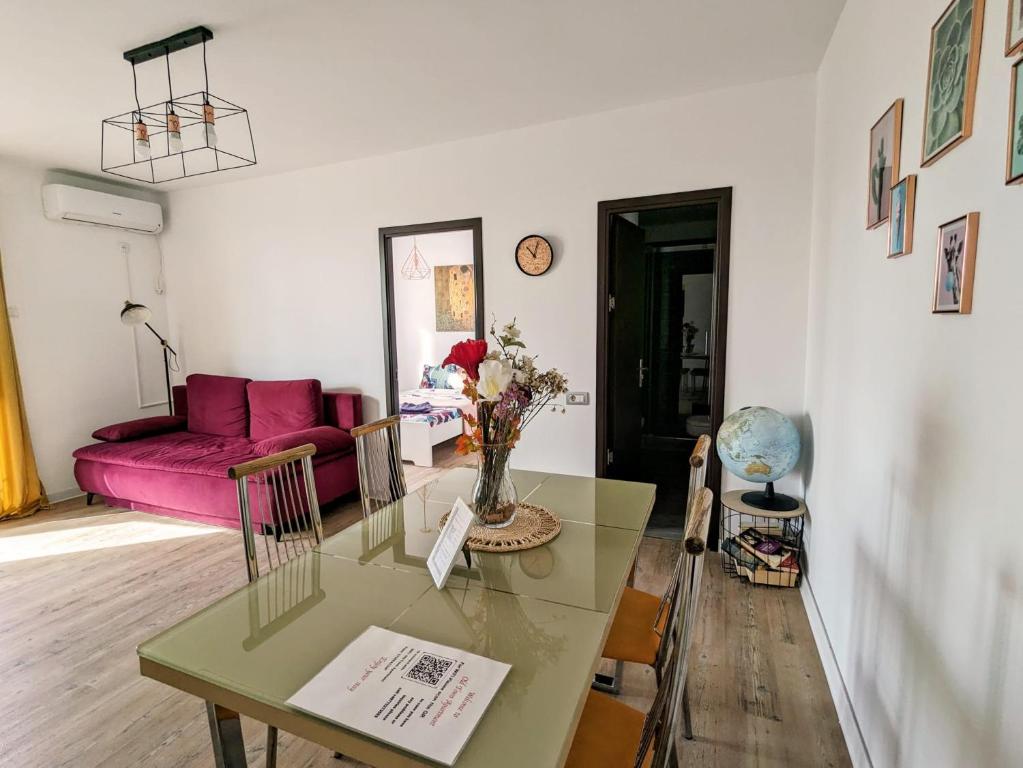 sala de estar con mesa y sofá rosa en Old town apartment, en Bucarest