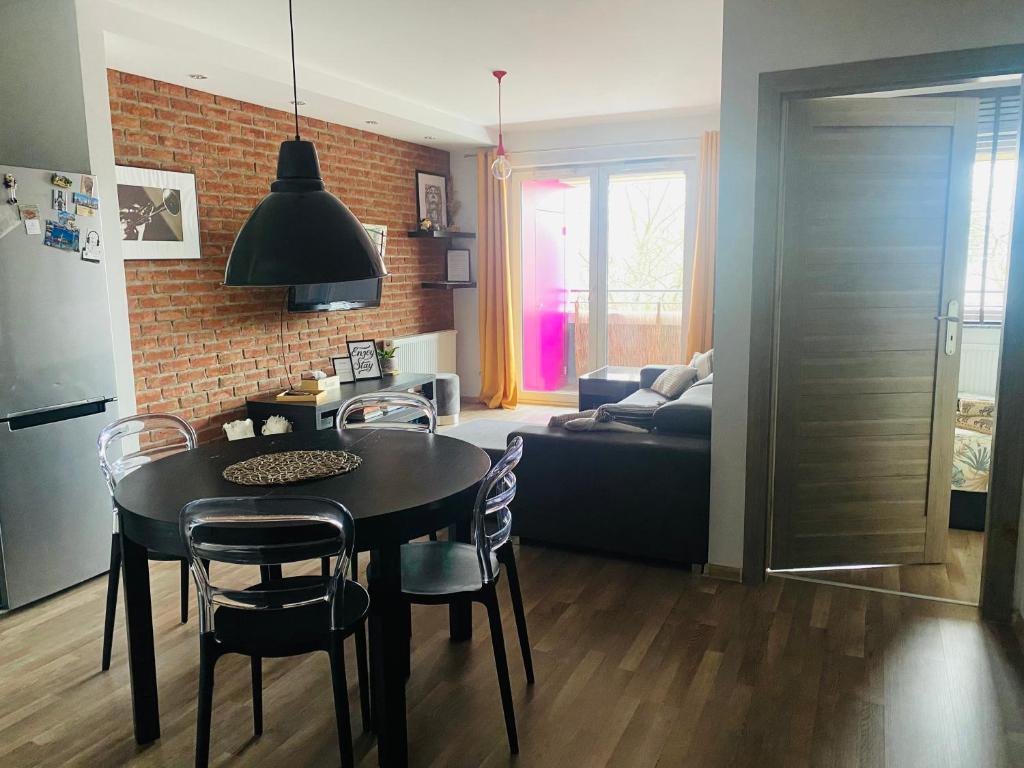 a kitchen and dining room with a table and chairs at Dyrekcyjna Apartment in Wrocław