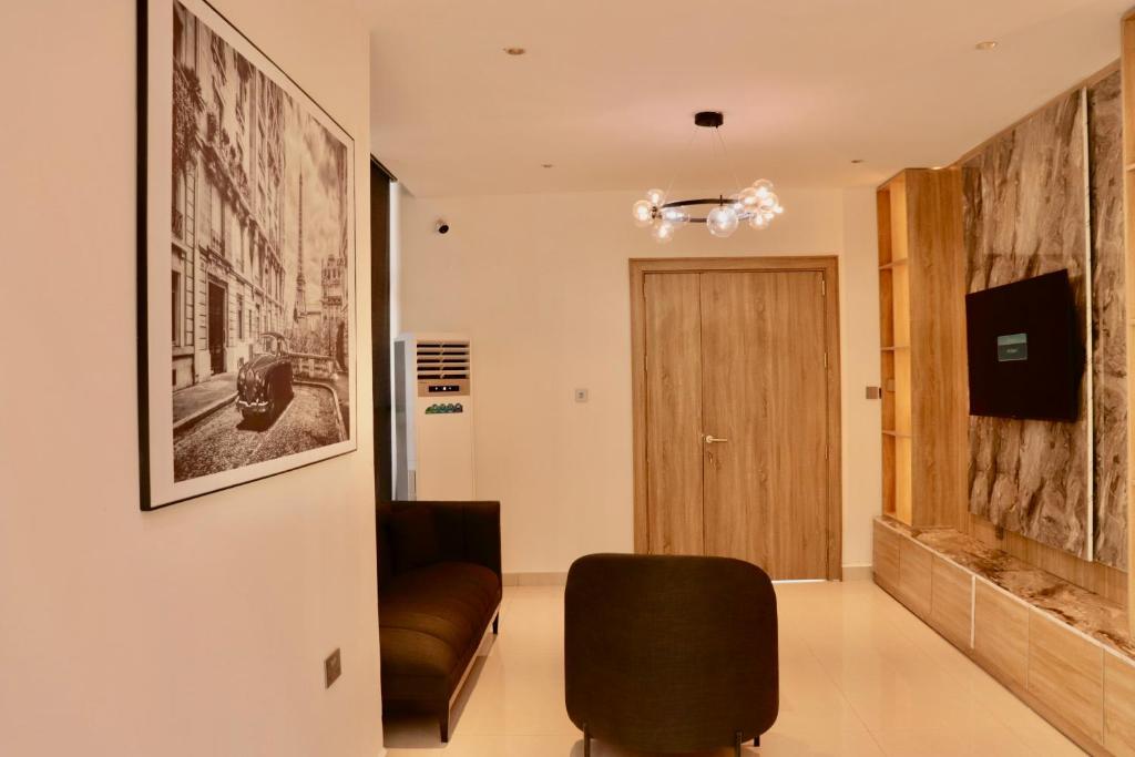 ein Wohnzimmer mit einem Stuhl und einer Tür in der Unterkunft Polo grand hotel in Maiduguri