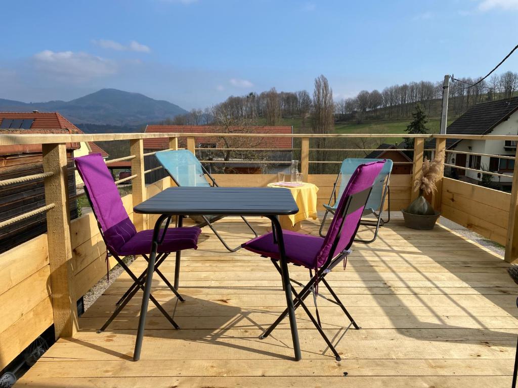 a table and chairs on a deck with a view at Au nid'Elma in Breitenau