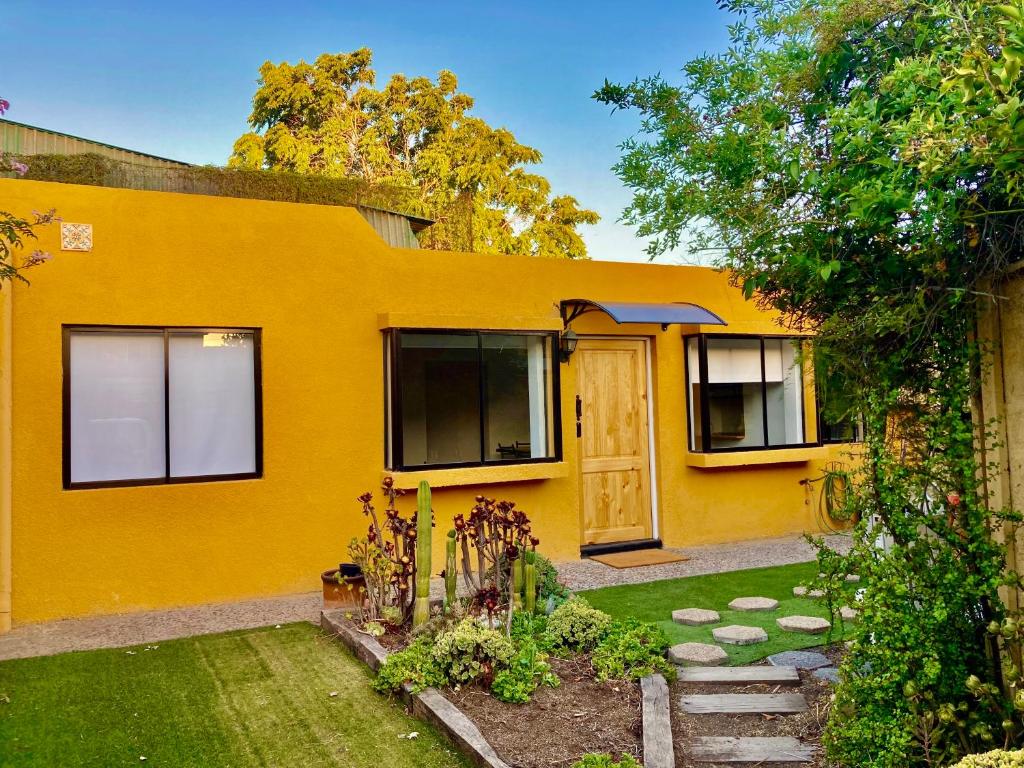 una casa amarilla con un jardín delante de ella en Urban Lodge Providencia, en Santiago