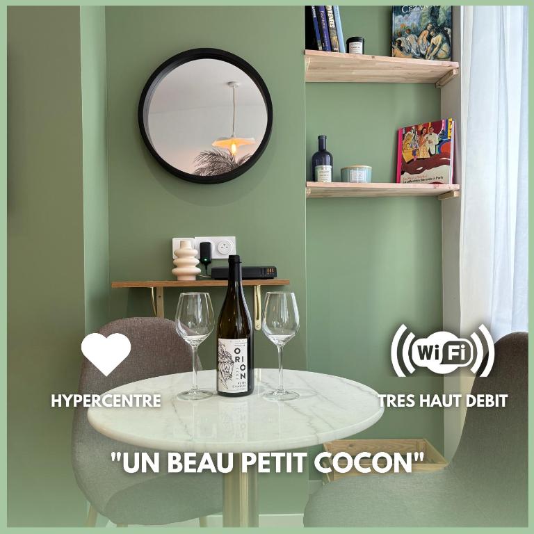- une table avec 2 verres à vin et un miroir dans l'établissement Le Baraban : Cocon hypercentre, à Saint-Étienne