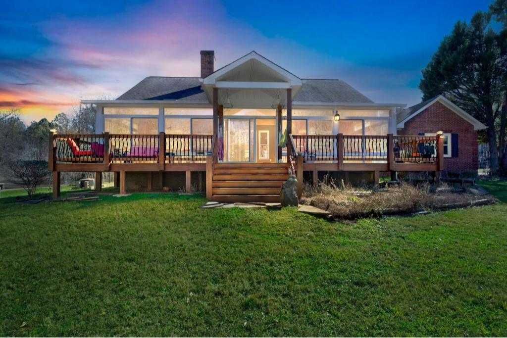 una grande casa con un grande ponte su un prato di Rustic Elegance- Farmhouse Retreat in Covington farmhouse a Covington