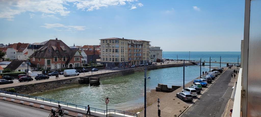 a city with cars parked next to a body of water at Une jolie vue - Appt 2 pièces Vue mer Balcon sud in Wimereux