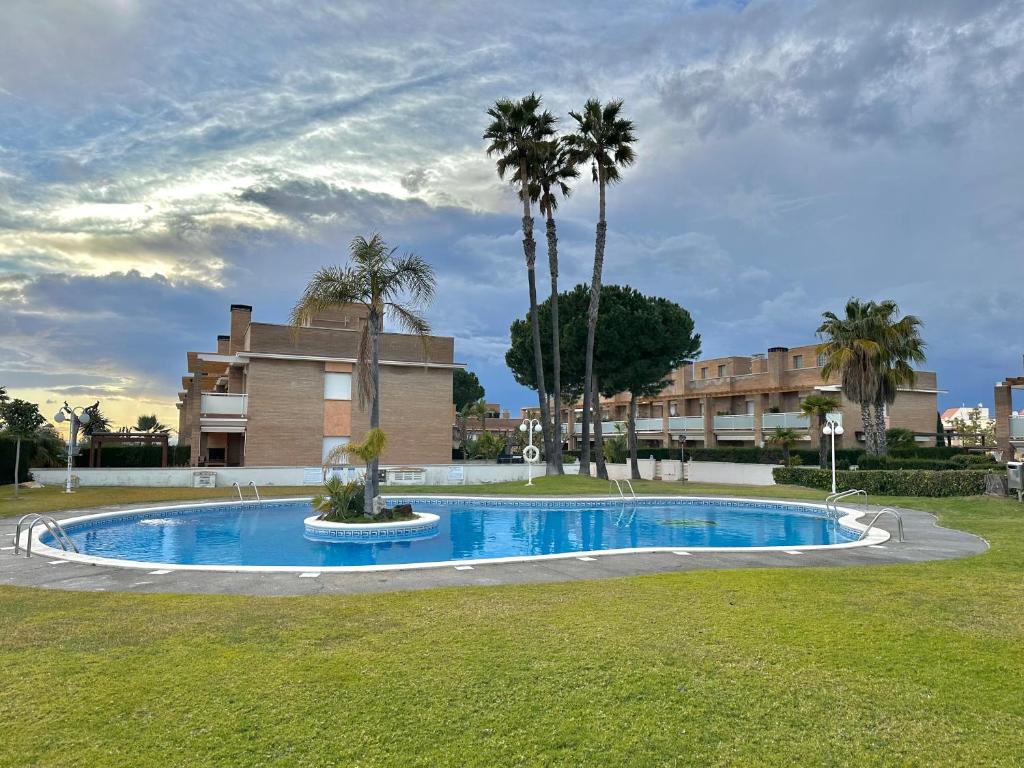 una piscina con palmeras y un edificio en Villa Alex Altafulla Hermosa casa con espectaculares vistas al mar y a tocar de una idílica calita, en Altafulla