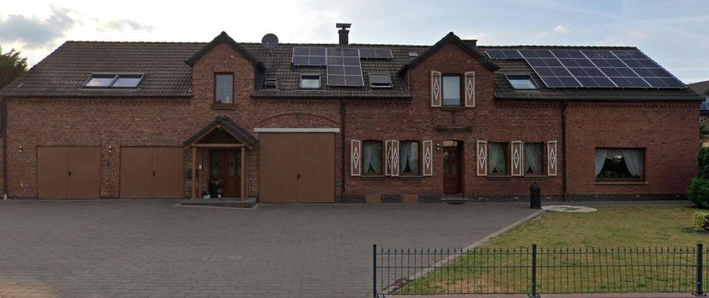 a large brick house with solar panels on the roof at Altes Haus in Elsdorf