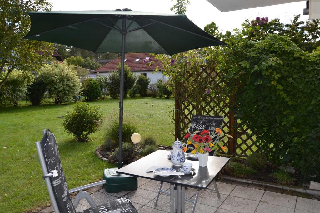 a table with an umbrella in a yard at Fewo Möwenweg 8 - Damme GM 69180 in Graal-Müritz