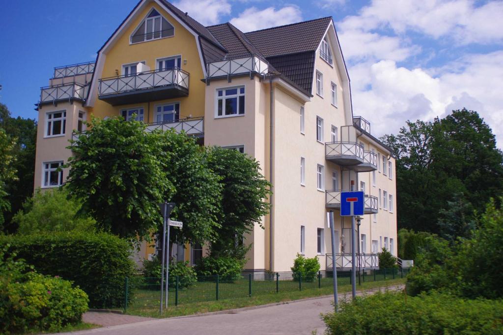 a yellow and white building with a black roof at Ferienwohnung Bülow GM 69131 in Müritz
