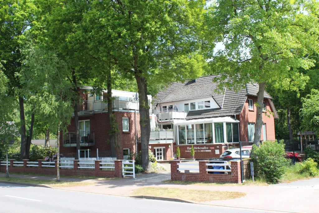 una casa di mattoni rossi con un albero di fronte di Haus Birkenallee Reckleben GM 69705 a Graal-Müritz