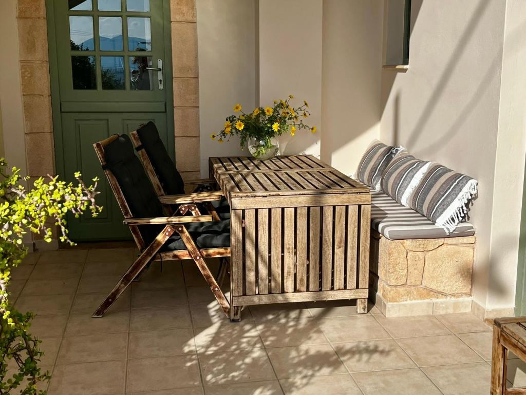 a porch with a chair and a table and a door at Aegina Town Home in Egina
