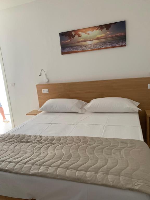 a bedroom with a white bed with a picture on the wall at Miriasol Bed and Breakfast in Capo Vaticano