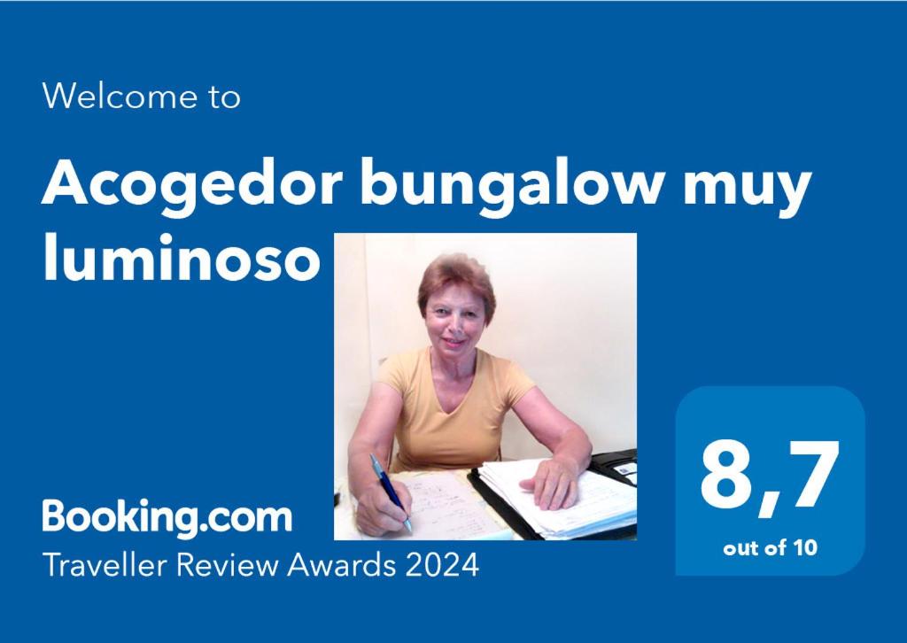 een vrouw aan een bureau met een pen en een foto bij Acogedor bungalow muy luminoso in Maspalomas