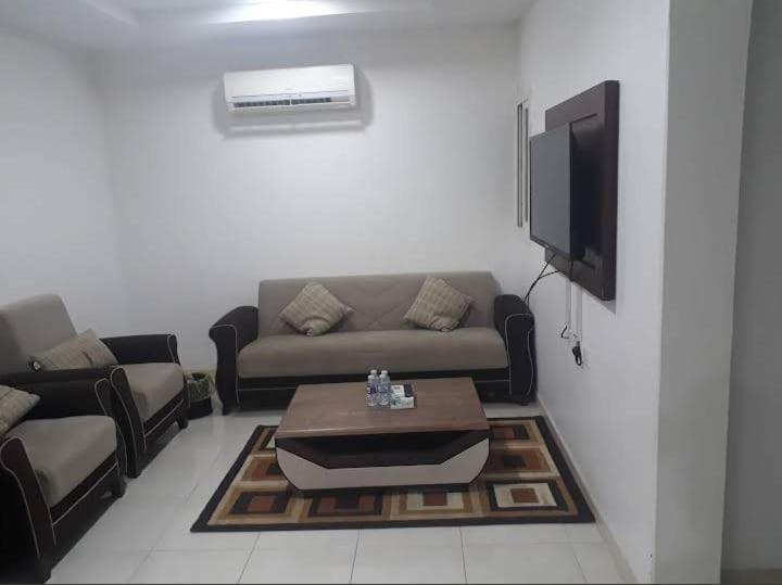 a living room with a couch and a tv at نجوم طابة الطيبة للشقق المخدومة in Al Jāmi‘ah