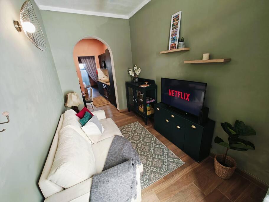 een woonkamer met een witte bank en een televisie bij Cosy Apartment in Senglea in Senglea
