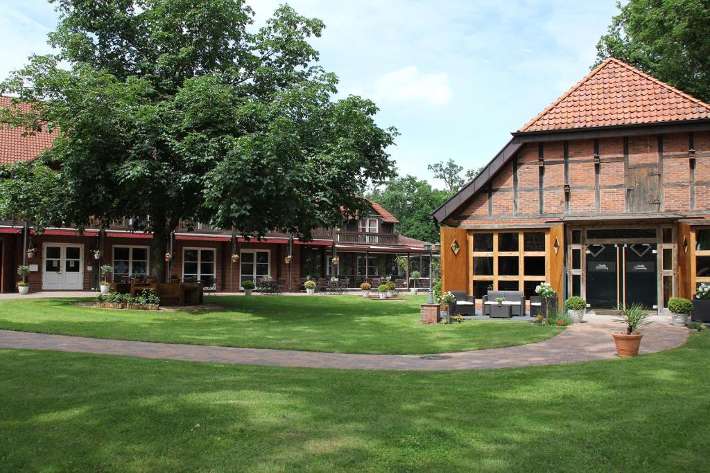 a large brick building with a grass yard next to it at Büchtmannshof in Wietze