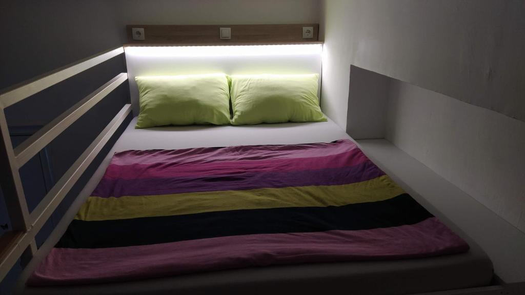 um quarto com uma cama com um cobertor arco-íris em Cozy Gallery - City Centre em Novi Sad
