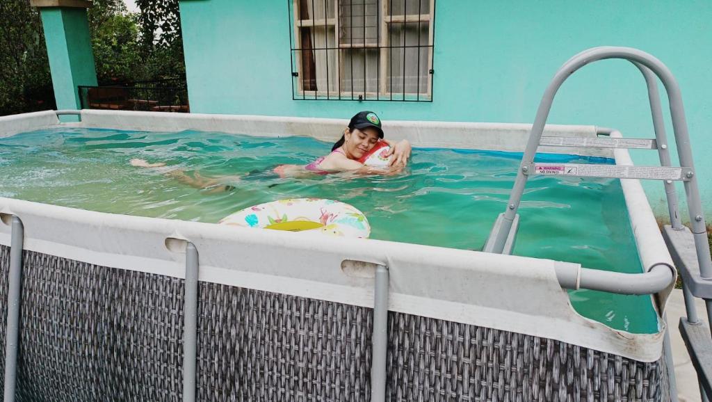 una mujer en un jacuzzi en una piscina en Cabaña blue jeans, en San Ramón