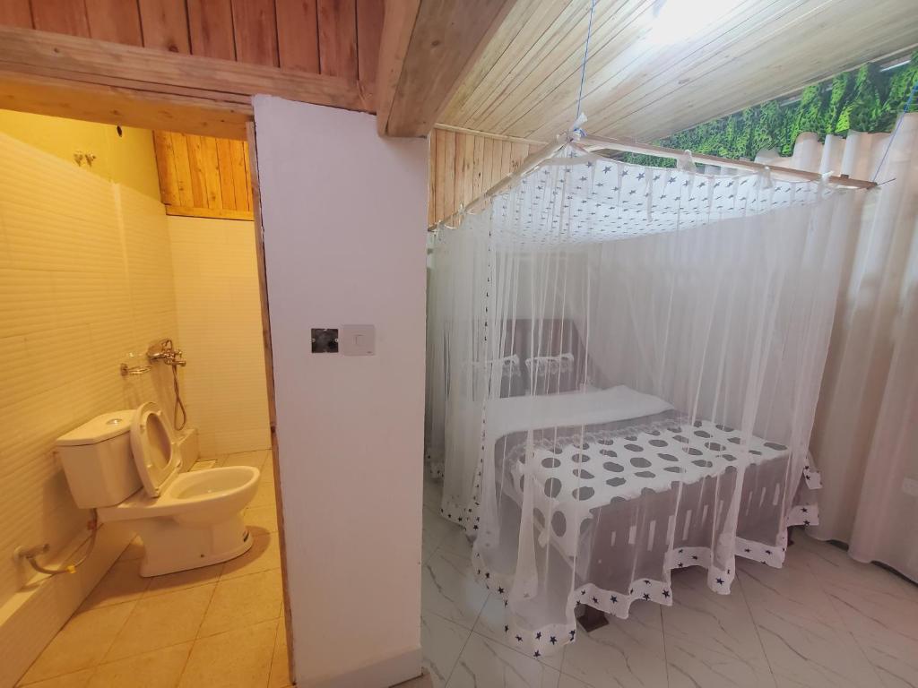 La salle de bains est pourvue d'une douche et de toilettes. dans l'établissement First Mayor' Garden, à Malamagambo