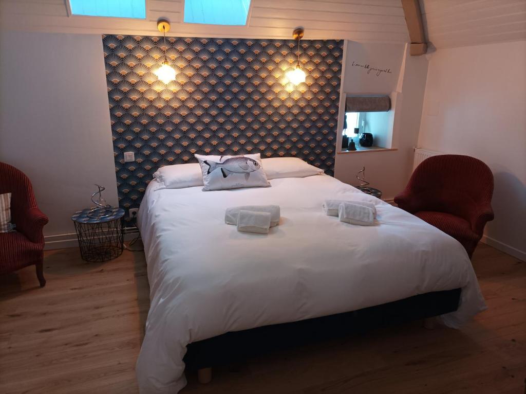 a bedroom with a large bed with two towels on it at Le clos du prieuré in Montjean-sur-Loire