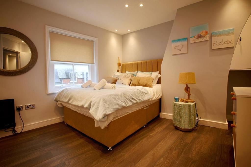 ein Schlafzimmer mit einem großen Bett und einem Fenster in der Unterkunft Best Beach Side Family Flat, Central Weymouth! in Weymouth
