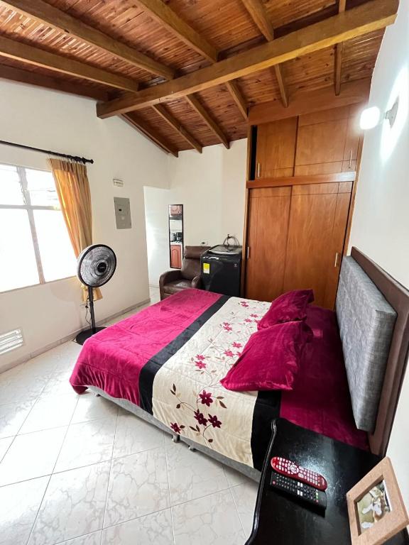 a bedroom with a large bed with a red comforter at aparta estudio en envigado in Envigado