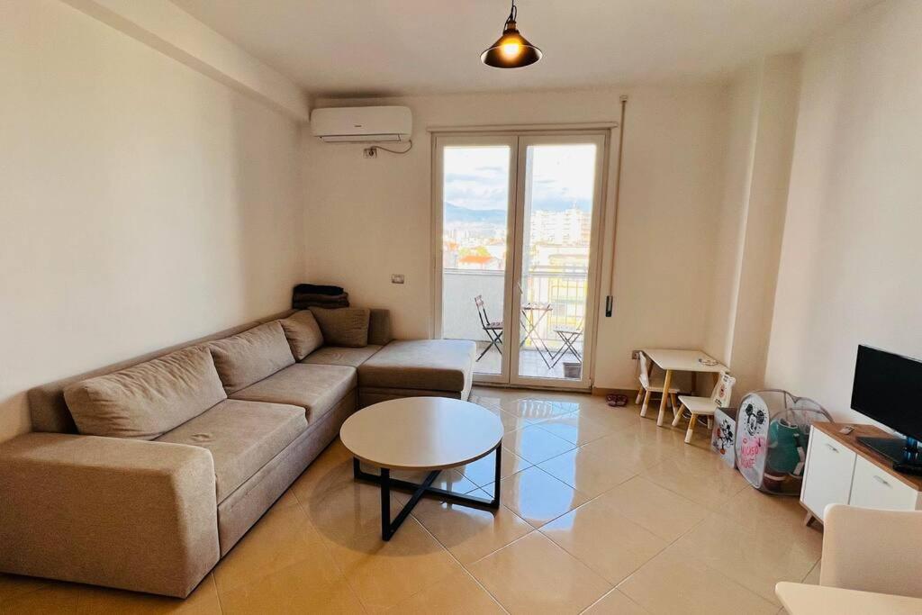 uma sala de estar com um sofá e uma mesa em Apartment Shkodra em Shkodër