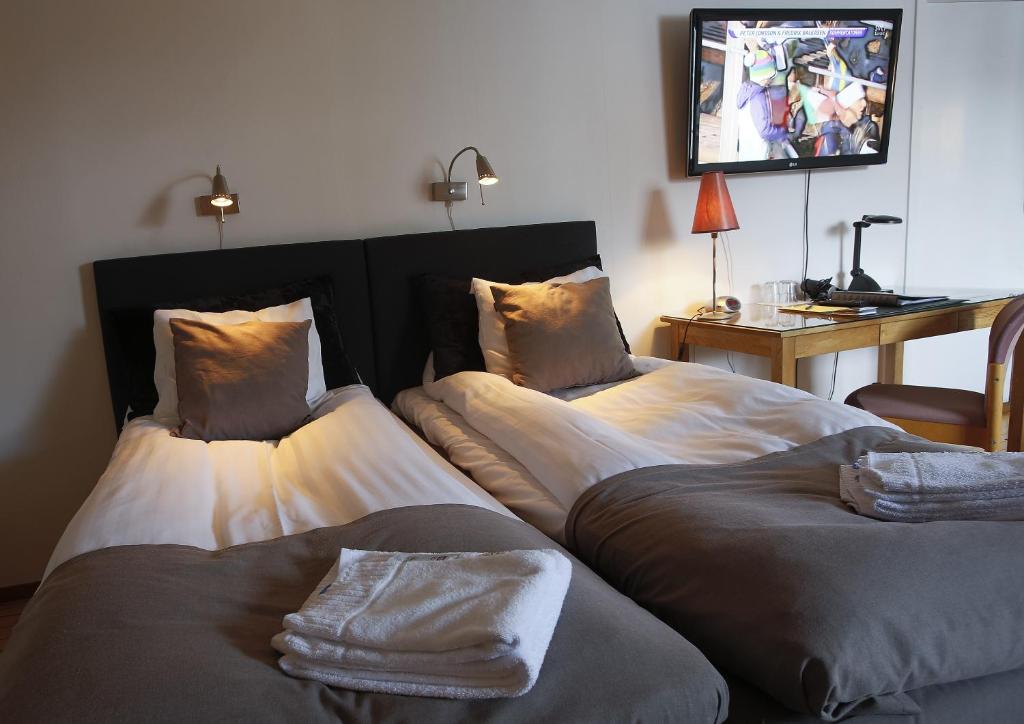 2 camas en una habitación con TV en la pared en Park Hotell en Luleå