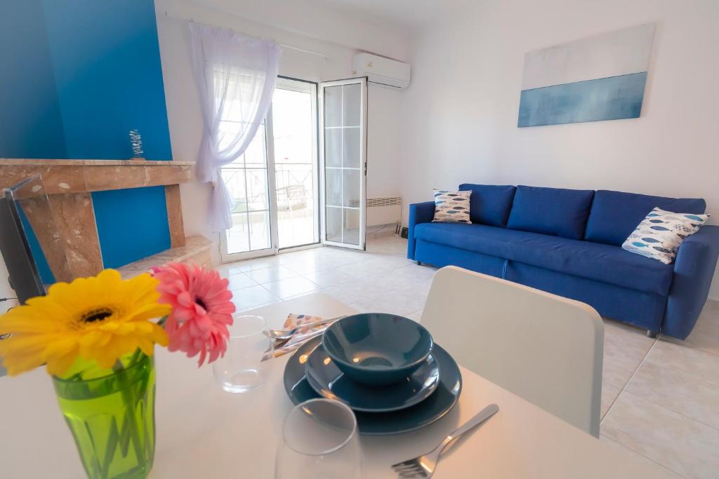 a living room with a table with a vase with flowers at 1-bedroom 500m away from the beach in Kallithea Halkidikis