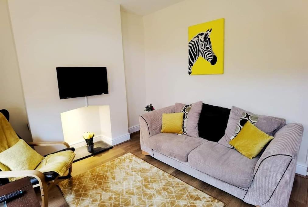 uma sala de estar com um sofá e uma imagem de zebra na parede em Kenrick Street Affordable Convenient 2 Bedroom House Central Location Sleeps 6 NG4 Postcode em Nottingham