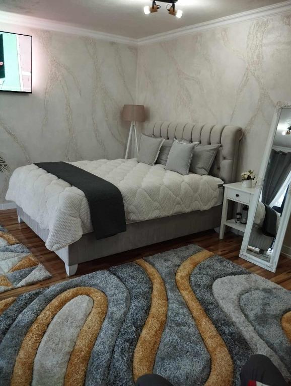 a bedroom with a large bed and a rug at Апартамент за гости Боляри 2 in Velingrad