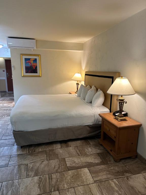 a hotel room with a bed and a table with lamps at Ramada by Wyndham Las Cruces Hotel & Conference Center in Las Cruces