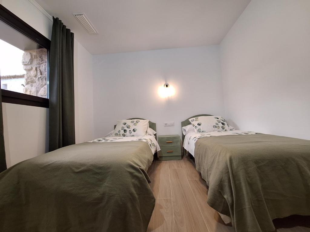 2 camas individuales en una habitación con ventana en Casa Rural Los Marqueses, en Valmuel